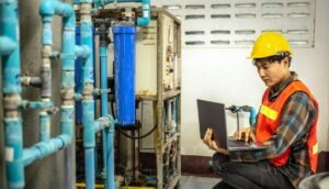 Engineer inspecting commercial reverse osmosis water purification system in a manufacturing facility